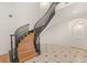 Elegant curved staircase with a dark railing and light wood steps in a bright foyer at 1905 Iron Ridge Dr, Las Vegas, NV 89117