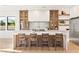 Modern kitchen with marble island, glass-front cabinets, open shelving, and stainless steel refrigerator at 1987 Orchard Mist St, Las Vegas, NV 89135