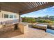 Beautiful outdoor kitchen with built in grill, counter seating, and a gorgeous pool and hot tub at 1987 Orchard Mist St, Las Vegas, NV 89135