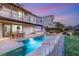 Backyard pool with spa, outdoor kitchen and dining area at dusk at 1987 Orchard Mist St, Las Vegas, NV 89135