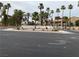 Street view of a well-maintained community with lush landscaping, palm trees, and attractive building architecture at 220 Mission Catalina Ln # 203, Las Vegas, NV 89107