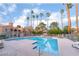 Enjoy this expansive community pool area surrounded by mature palm trees and stylish poolside furnishings at 221 Mission Catalina Ln # 104, Las Vegas, NV 89107