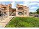 Two-story building with stucco finish, stairs leading to upper units, and lush green landscaping at 221 Mission Catalina Ln # 104, Las Vegas, NV 89107
