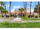 A one-story stucco building with a red tile roof is surrounded by mature landscaping and palm trees at 221 Mission Catalina Ln # 104, Las Vegas, NV 89107