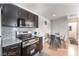 Modern kitchen featuring stainless steel appliances, contrasting dark cabinets, and a cozy dining area at 221 Mission Catalina Ln # 104, Las Vegas, NV 89107