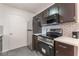 Well-equipped kitchen featuring stainless steel appliances, dark cabinetry, and tiled backsplash at 221 Mission Catalina Ln # 104, Las Vegas, NV 89107