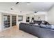 Open living room boasts a comfortable gray sectional sofa and glass doors to the outside at 221 Mission Catalina Ln # 104, Las Vegas, NV 89107