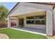 Backyard patio featuring covered space, synthetic grass, rock features, and sliding glass door at 2555 Moonlight Valley Ave, Henderson, NV 89044
