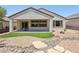Landscaped backyard featuring decorative rocks, artificial turf, covered patio, and privacy at 2555 Moonlight Valley Ave, Henderson, NV 89044