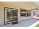 Covered patio with views of landscaped yard featuring stone, grass, and sliding glass doors at 2555 Moonlight Valley Ave, Henderson, NV 89044