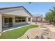 Beautiful desert landscaped backyard with patio, decorative rock, and synthetic grass at 2555 Moonlight Valley Ave, Henderson, NV 89044
