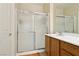 The bathroom featuring a glass-enclosed shower, single sink with vanity, and neutral tile flooring at 2555 Moonlight Valley Ave, Henderson, NV 89044