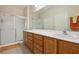 Bathroom featuring a shower with sliding glass door, double sinks, and a neutral color palette at 2555 Moonlight Valley Ave, Henderson, NV 89044