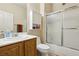 Bathroom featuring a white vanity, toilet, and tub shower with sliding glass doors at 2555 Moonlight Valley Ave, Henderson, NV 89044