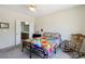 Cozy bedroom features bright, colorful bedding, a ceiling fan, and access to an en-suite bathroom at 2555 Moonlight Valley Ave, Henderson, NV 89044