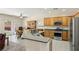 Open kitchen showcasing wood cabinets, stainless steel appliances, and views of the dining area and backyard at 2555 Moonlight Valley Ave, Henderson, NV 89044