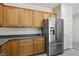 Kitchen boasts modern stainless steel refrigerator and ample wood cabinet space for maximum storage and convenience at 2555 Moonlight Valley Ave, Henderson, NV 89044