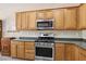 Kitchen featuring stainless steel oven and microwave, accompanied by abundant wood cabinetry for optimal organization at 2555 Moonlight Valley Ave, Henderson, NV 89044