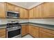 Well-equipped kitchen with stainless steel oven, microwave, and plentiful wood cabinetry, offering ample storage at 2555 Moonlight Valley Ave, Henderson, NV 89044