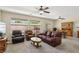 Spacious living room with comfortable seating, two ceiling fans, and views of the backyard at 2555 Moonlight Valley Ave, Henderson, NV 89044