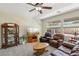 Bright living area offering comfortable seating, display cabinet and natural light from the windows at 2555 Moonlight Valley Ave, Henderson, NV 89044
