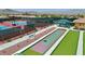 View of the tennis and bocce ball courts, with lush landscaping and mountains in the distance at 2555 Moonlight Valley Ave, Henderson, NV 89044