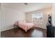 Cozy bedroom featuring wood floors, neutral walls and a large window for natural light at 2745 Poppyseed Way, Las Vegas, NV 89142