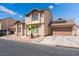 Low angle exterior view of a two-story home featuring neutral stucco and a small palm tree in the front yard at 2745 Poppyseed Way, Las Vegas, NV 89142