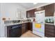 Functional kitchen featuring tile countertops, modern appliances, and dark wood cabinetry at 2745 Poppyseed Way, Las Vegas, NV 89142