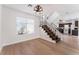 Inviting living room with light wood floors and view of the staircase and kitchen with dark cabinetry at 2745 Poppyseed Way, Las Vegas, NV 89142