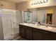 Bathroom featuring double sinks, granite countertop, and framed shower with sliding glass door at 2822 Chetco River St, Laughlin, NV 89029