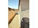 Side yard featuring a gravel ground cover, bordering a vinyl fence with a glimpse of a hot tub at 2822 Chetco River St, Laughlin, NV 89029