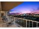 Enjoy expansive city views from this tiled balcony with stylish seating area at twilight at 3111 Bel Air Dr # 21A & 21C, Las Vegas, NV 89109