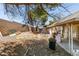 View of the backyard with block wall, covered patio, concrete, and items scattered across the yard at 3127 Kennewick Dr, Las Vegas, NV 89121