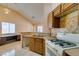 Well-lit kitchen with tile floors, dual basin sink, wood cabinets, and a white gas range oven at 3127 Kennewick Dr, Las Vegas, NV 89121