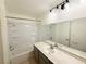 Bathroom featuring a shower-tub combo, large mirror and gray vanity at 3270 Liahona Way, Las Vegas, NV 89121