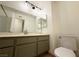 Bathroom featuring a vanity with gray cabinets, large mirror, and toilet at 3270 Liahona Way, Las Vegas, NV 89121