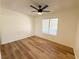 Bright bedroom features wood-look flooring, a ceiling fan, and a large window at 3270 Liahona Way, Las Vegas, NV 89121