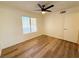 Bedroom featuring wood-look flooring, a window, ceiling fan, and white door at 3270 Liahona Way, Las Vegas, NV 89121