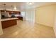 Bright living room with tile flooring and a view of the modern kitchen appliances at 3270 Liahona Way, Las Vegas, NV 89121