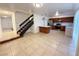 Open-concept living room, staircase, and kitchen with tile floors and stainless steel appliances at 3270 Liahona Way, Las Vegas, NV 89121