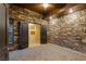 Stone-walled bedroom with gray carpet and walk-in closet with custom shelving and drawers at 33 Promontory Ridge Dr, Las Vegas, NV 89135