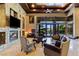 Elegant living room features a stone fireplace, wood ceiling, and large windows overlooking the outdoor space at 33 Promontory Ridge Dr, Las Vegas, NV 89135