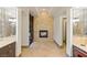 The luxurious main bath includes marble tile, fireplace, chandelier, and access to the main bedroom at 33 Promontory Ridge Dr, Las Vegas, NV 89135