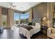 Cozy main bedroom with hardwood floors, fan, ensuite bath and lots of natural light from the large windows at 33 Promontory Ridge Dr, Las Vegas, NV 89135