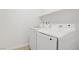 Well-lit laundry area featuring white appliances and upper shelving for storage, ensuring efficient organization at 3621 Arcadian Sea St, Las Vegas, NV 89106