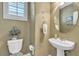 Half bath with a pedestal sink, tile floors, decorative mirror and fixtures at 4408 Oasis Plains Ave, North Las Vegas, NV 89085