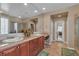 Spacious bathroom with double vanity, tile floors, framed mirrors, and glass shower with a view into the bedroom at 4408 Oasis Plains Ave, North Las Vegas, NV 89085
