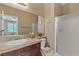 Bathroom featuring cherry cabinets, framed mirror, solid surface counters, and glass enclosed shower at 4408 Oasis Plains Ave, North Las Vegas, NV 89085