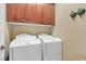 Convenient laundry room equipped with a washer, dryer, and built in upper cabinets for storage at 4408 Oasis Plains Ave, North Las Vegas, NV 89085